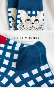 Close-up of knit crew socks featuring blue checkerboard and pink cat jacquard patterns