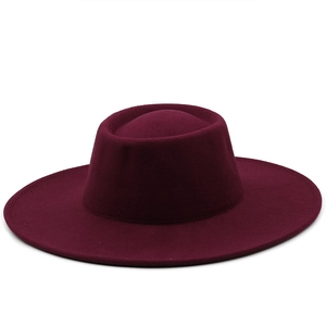 Detailed view of the burgundy wool felt boater hat with a flat top and wide brim design