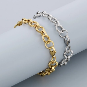 Gros plan de bracelets chaîne à maillons torsadés dorés et argentés sur un présentoir