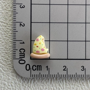 Miniature resin pizza charm shown next to a centimeter ruler for precise size measurement