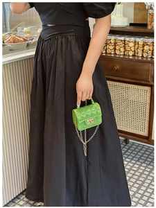 Close-up of bright green quilted jelly bag with gold twist lock and chain strap