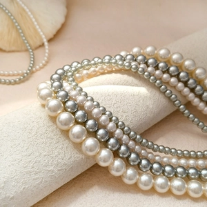 Macro shot of various pearl sizes and colors from white to silver grey on a textured stand