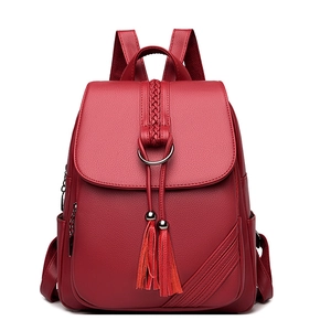 Red PU leather women's backpack with fringe and woven details on a white background