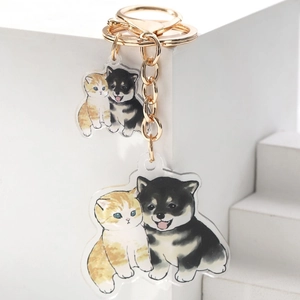 Detail of acrylic keychain with cute orange cat and black shiba inu dog charms
