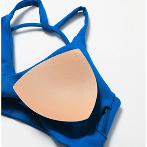 Detail of navy blue sports bra with removable triangular nude chest pads for workout