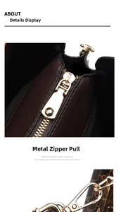 Detail of dark brown leather handbag showing golden metal zipper and side hook hardware