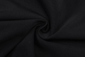 Gros plan sur un tissu en maille côtelée noire montrant texture douce et détails de fibres