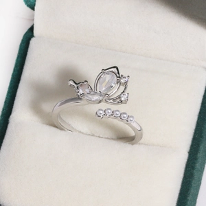Detail of silver butterfly ring with zircons and pearls on green velvet box