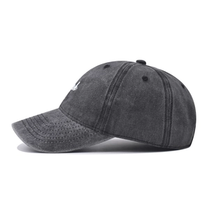 Detail of embroidered 'Luck' script on charcoal gray washed cotton baseball cap