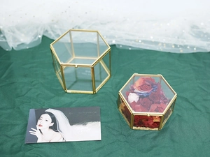Detail of hexagon glass jewelry box with gold metal frame and interior rose decoration