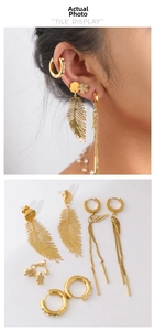 Close-up of gold-plated leaf earrings and feathered tassels with zircon on ear cuff