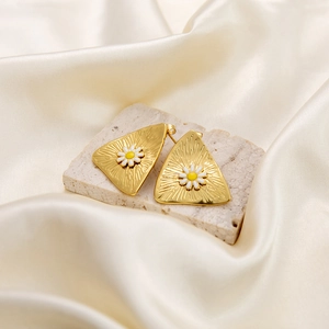 Triangle gold stud earrings with daisy floral inlay on a textured stone display