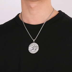 Detailed close-up of a silver tree of life hollow round pendant on a steel chain