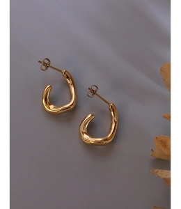 Detailed close-up of 18K gold-plated stainless steel C-shaped earrings with irregular surface
