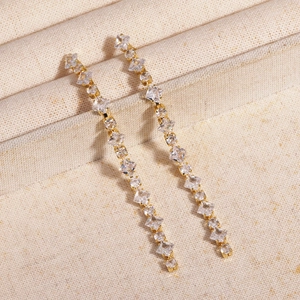 Detail view of long tassel earrings with sparkling square rhinestones in golden finish