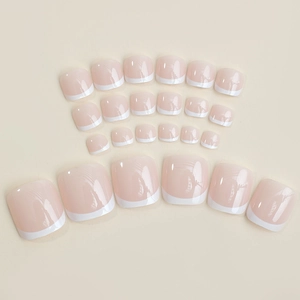 Classic French tip press-on toenails in nude pink with white tips for a clean pedicure look
