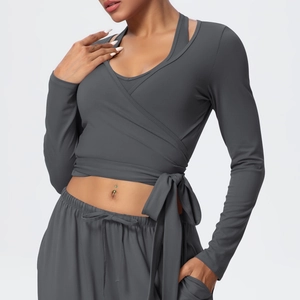 Detail of dark grey wrap sports top with waist ties and matching high-waisted yoga pants