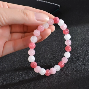 Detail of beaded yoga bracelet with pink, dark red and white crystals in hand shot