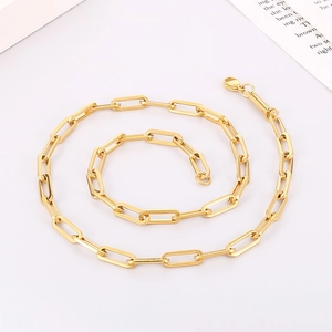 Detailed close-up of a gold-plated stainless steel paperclip chain necklace on a white surface