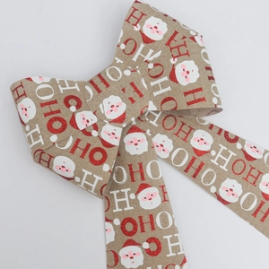 Detail of burlap Christmas bow with red HO HO HO text and Santa Claus patterns