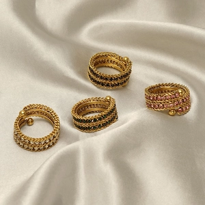 Detail of 18K gold plated spiral rings with multi-color zircons on silk background
