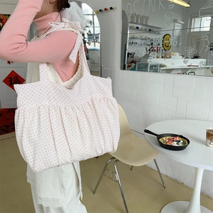 Detailansicht der weißen Segeltuchtasche mit rosa Punkten und plissierter Rock-Textur