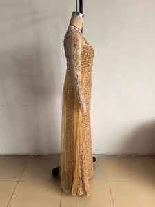 Détail de la robe de soirée dorée avec broderie en dentelle et cape en tulle