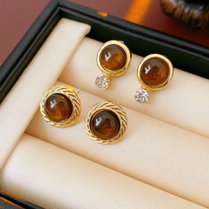 Details von Vintage-Resin-Ohrringen mit braunen Steinen auf Samt-Display