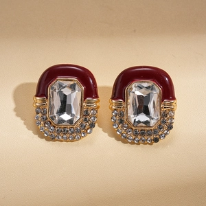 Detail view of vintage gold earrings with burgundy enamel and square zircon crystals