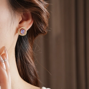 Dettaglio ravvicinato di un orecchino in argento con zircone viola e finitura dorata