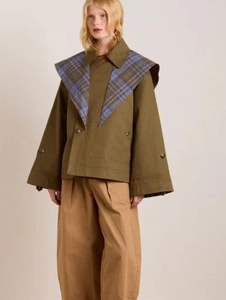 Detail of olive green loose jacket with oversized blue plaid collar and wide buttoned cuffs