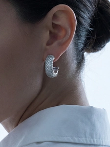 Detailed view of silver C-shaped hoop earrings with micro-pave cubic zirconia stones