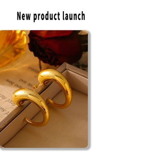 Macro detail of chunky 18k gold plated C-shape hoop earrings with high polish mirror finish