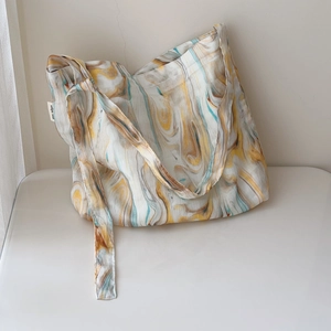Close-up of marble pattern print and brand label on large canvas tote bag