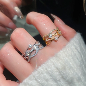 Close-up of a multi-layer wave ring with pearls and pavé cubic zirconia in gold and silver