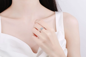 Close-up of heart-cut moissanite ring in silver-white metal worn by a model