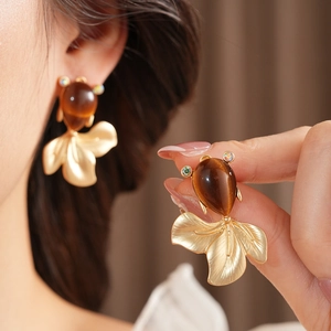 Detail of vintage fish earrings with rhinestones and cat-eye stones in antique gold