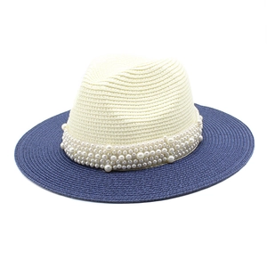 Detailed shot of two-tone woven straw panama hat with elegant pearl band decoration