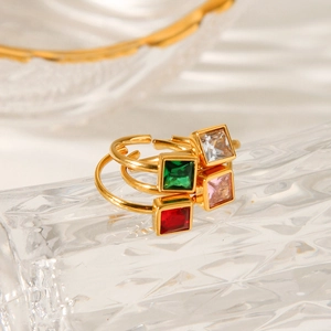 Close-up of four-piece gold plated adjustable rings set with colorful square zircons