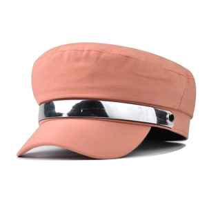 Detailed shot of pink captain hat with silver metal band and decorative letter M logo