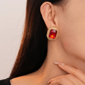 Close-up of vintage dark red rectangular gemstone earrings with gold textured frame