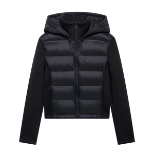 Detail of black hooded puffer jacket showing hybrid nylon quilting and knit panels