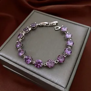 Elegant silver tennis bracelet with round purple zircon stones on a silk display