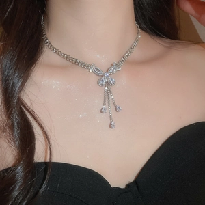 Close-up of model wearing silver butterfly tassel necklace with sparkling zircon