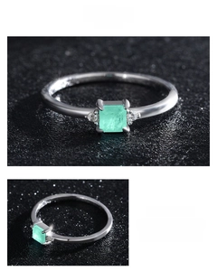 Macro detail showing square emerald-cut green gemstone on polished 925 silver band