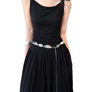 Élégante ceinture chaîne en métal argenté avec feuilles ovales sur une robe noire