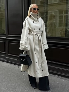 Detailed view of the double-breasted buttons and matching belt on this beige trench coat