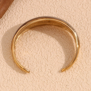 Detail of minimalist open bangle featuring two-tone design with 18K gold plated finish