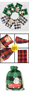 Detail of Christmas buffalo plaid drawstring gift bags with festive cartoon patterns