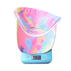 Detailed view of tie-dye baseball cap weighing 74g on a blue digital scale